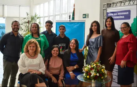 Grupo de pessoas junto com adolescente reunidos para premiação do Selo UNICEF 