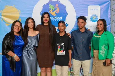 Grupo de pessoas junto com adolescente reunidos para premiação do Selo UNICEF 
